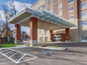 辛辛那提Hampton Inn & Suites Cincinnati Midtown Rookwood的遮阳篷在大楼前停车场