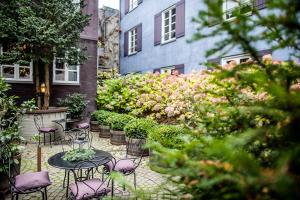 奥胡斯普罗旺斯别墅酒店的花园内带桌椅的庭院