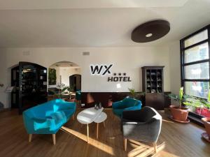 布拉迪斯拉发WX Hotel的客厅配有蓝色的椅子和桌子