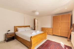 巴斯GuestReady - A Bohemian Home in Bath的一间卧室配有一张床和一个木制橱柜