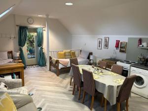 锡廷伯恩Alpaca Lodge的厨房以及带桌椅的起居室。