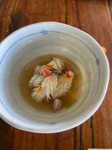 Ban KlangHomestay&ChaoleySeafoodrestaurant的桌上一碗汤,面条上放着面条