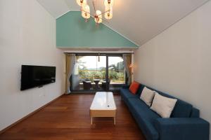 扶余Park Art Villas的客厅配有蓝色的沙发和电视