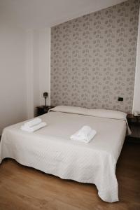 CervinoGuardanapoli的卧室配有白色的床和2条毛巾