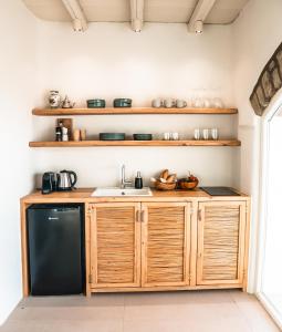 阿吉亚艾里尼帕罗Nerea Sunset View Apartment的厨房配有木制橱柜和黑色冰箱。