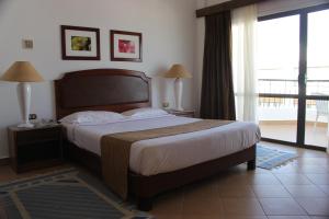 赫尔格达马林海滨度假村的一间带大床的卧室和一个阳台