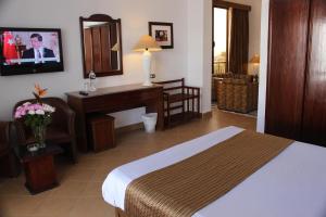赫尔格达马林海滨度假村的酒店客房配有一张床、一张书桌和一台电脑