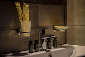 卡兹贝吉Hotel Misty Mountain的浴室水槽,内有4瓶
