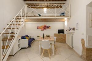 锡耶纳Casa Vezzosa的客厅配有高架床和桌子