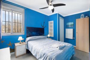 罗塔El Marinero的蓝色卧室配有床和吊扇