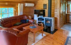 VallrunAmazing Home In Fllinge With Wifi的客厅设有真皮沙发和壁炉
