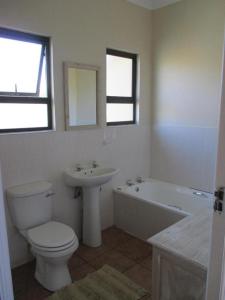 咖啡湾Sea View的浴室配有卫生间、盥洗盆和浴缸。