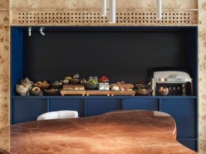 雅典The Newel Acropolis的一间设有蓝色橱柜和一张桌子的用餐室