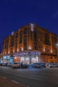 达曼دانة الشرقية للشقق المخدومة بالدمام Danat Al Sharqiah Serviced Apartments的一座大型建筑,前面有汽车停放