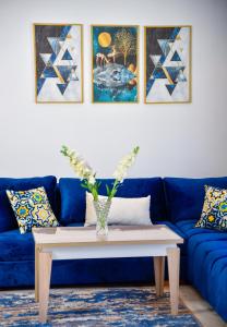 卡萨布兰卡Family Aparthotel的客厅配有蓝色的沙发和桌子