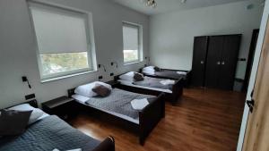 谢拉兹Baza noclegowa Mistral的客房设有三张床、一张沙发和两扇窗户。
