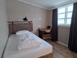 埃基斯蒂尔埃基斯蒂尔湖滨酒店的一间卧室配有一张带书桌的床和窗户。
