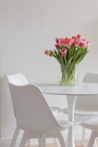 华沙Elegant & Cozy Apartment Pańska by Renters的白色桌子上一束粉红色的花瓶