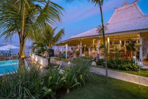 蓝梦岛Paus Putih Hotel的一个带游泳池和棕榈树的度假村