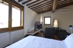 佛罗伦萨托斯卡内利古宅酒店的一间卧室配有一张床、一张桌子和一把椅子
