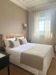 阿威罗若昂派得罗酒店的卧室配有一张大白色床和窗户
