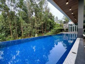 史里肯邦安Seri Kembangan Equine Villa with Pool by Iconique的蓝色房子中的无边游泳池