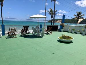 纳塔尔Ponta Negra Suites & Apart的一个带椅子和遮阳伞的庭院和大海