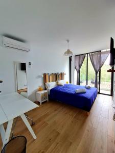 卡拉加尔达纳Mitjana's House的一间卧室配有一张蓝色的床和一张桌子