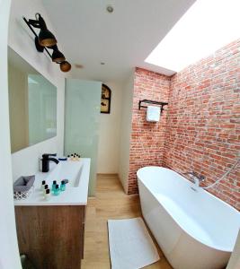 卡拉加尔达纳Mitjana's House的一间带白色浴缸和砖墙的浴室