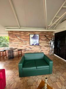 加拉加斯Mesod Jungle Boutique的客厅设有绿色沙发和砖墙