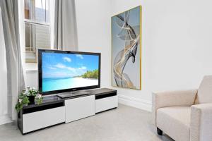 悉尼Modern 4B2B house@Glebe的一间带电视和沙发的客厅