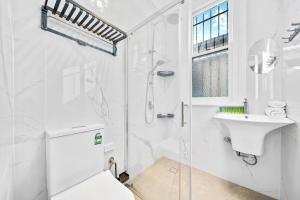 悉尼Modern 4B2B house@Glebe的带淋浴和盥洗盆的白色浴室