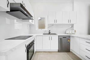 悉尼Modern 4B2B house@Glebe的白色的厨房配有水槽和洗碗机