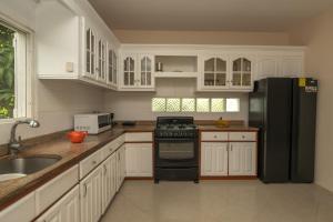 黎明海滩Dawn Beach Estate - 3 bedroom Apartment Villa villa的厨房配有白色橱柜和黑色冰箱。