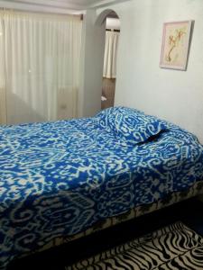 巴克里索莫雷诺港Palma del Mar 2的一间卧室配有一张带蓝色棉被的床