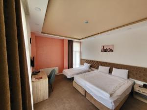 巴库Venera Hotel的酒店客房配有两张床和一张书桌
