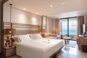 贝尼蔡斯Angsana Corfu Resort & Spa的一间带白色大床的卧室和一间客厅