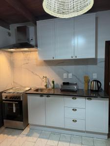 科洛尼亚-德尔萨克拉门托Lo de Adela Incluye 2 bicis的厨房配有白色橱柜、水槽和炉灶。