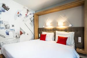 布达佩斯Up Hotel Budapest的卧室配有带红色枕头的大型白色床