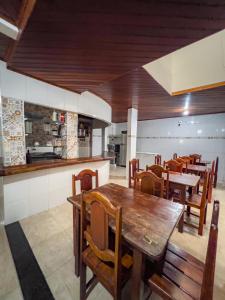莫罗圣保罗pousada Vitoria的一间带木桌椅的餐厅和一间厨房