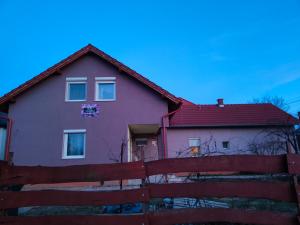 塞克希费黑瓦尔Bella Vendégház的一座红色屋顶和围栏的房子