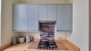 朴次茅斯Southsea Escape Coastal Apartment, 2 double bedrooms的厨房配有白色橱柜和炉灶。
