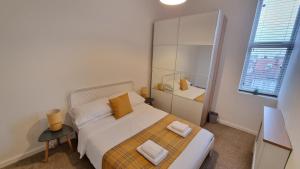 朴次茅斯Southsea Escape Coastal Apartment, 2 double bedrooms的一间卧室配有一张床,上面有两条毛巾
