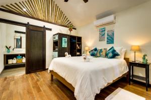 玛雅湾Azure Del Mar的卧室配有带蓝色枕头的大型白色床