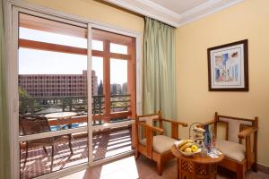 马拉喀什Grand Mogador Menara & Spa的客房设有带桌子和窗户的阳台。