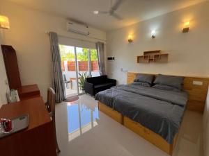 迪古拉The Wave Dhigurah的一间卧室设有一张床和一间客厅。