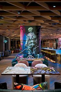 都柏林NYX Hotel Dublin Portobello的配有桌椅的餐厅,以及士兵的画