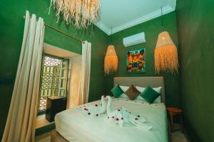 马拉喀什Hotel & Riad Veridis的一间卧室配有一张带绿色墙壁和吊灯的床。
