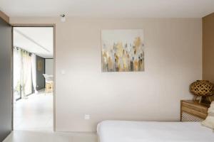 伊格涅La casa Irignoise的白色的房间,配有一张床和墙上的绘画