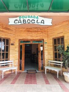 阿尔特杜尚Pousada Cabocla的前面有两长椅的建筑